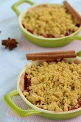 Plum crumble with spices on white background. Summer crispy fruit dessert. Tasty breakfast. Selective focus
