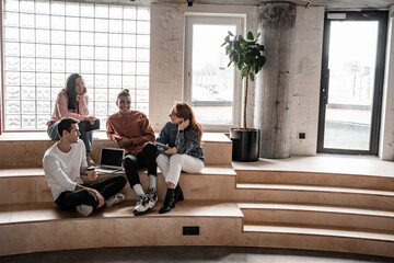 interracial students smiling while sitting on stairs