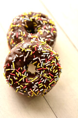 donuts al cioccolato ciambelle dolci al cioccolato con confetti colorati