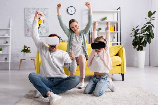 Excited family in vr headsets sitting on carpet near mother. - Powered by Adobe