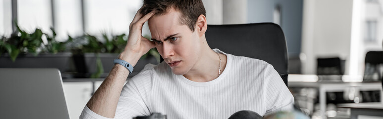 worried student looking at laptop, banner