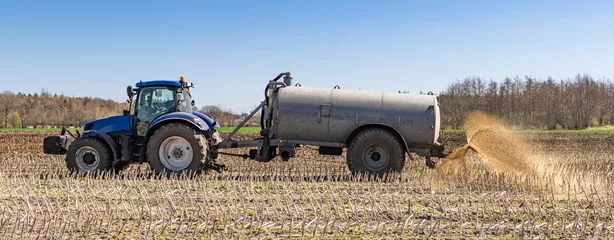 Deurstickers Tractor with slurry tanker fertilising in the field CP5140 © Wolfgang Jargstorff