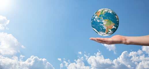 Hands holding a planet, earth on a background of nature blue sky with beautiful white clouds and sunlight.Sustain earth concept. Elements of this image furnished by NASA