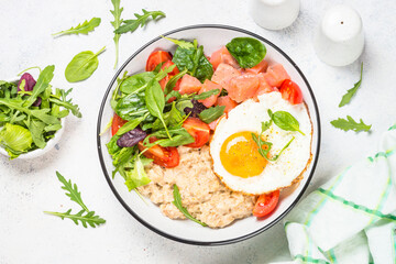 Savory breakfast with oatmeal, salmon and salad.