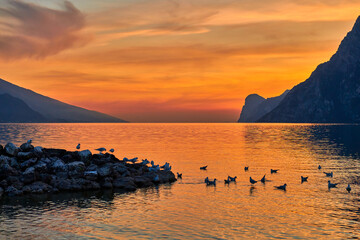 View of the beautiful Lake Garda surrounded by mountains, Scenic view of sunset at Lake Garda in...