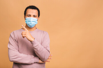 Coronavirus. African american black man wearing hygienic mask to prevent infection, airborne respiratory illness such as flu, 2019-nCoV. Isolated on beige background.