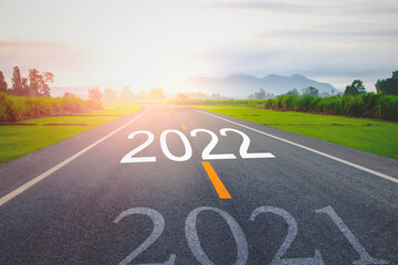 Concept new year With The word 2021 to 2022 Written on The asphalt  road in country road Decorate orange light for beauty With With views of rice fields on both sides Concept for the new year of 2022