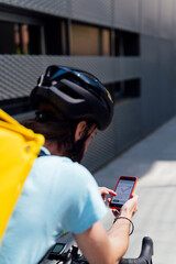 Delivery man on bicycle with smartphone