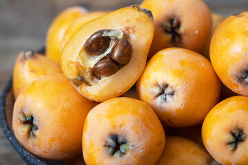 Fresh, ripe loquat on a wooden background.