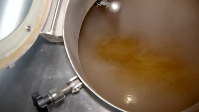 boiling beer wort in big stainless steel reservoir