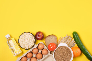 fruits, vegetables, cereals, bread, noodles and a bottle of water on a yellow background copy space