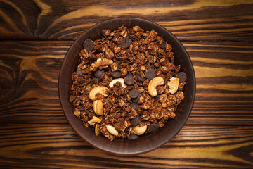 Chocolate granola cereal with nuts in a bowl.