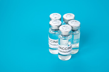 Production of coronavirus vaccine, ampoule with medicine on blue medical background