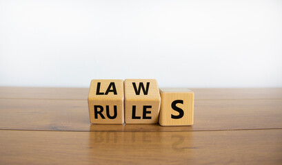 Laws or rules symbol. Turned cubes and changed the word 'rules' to 'laws'. Beautiful wooden table, white background, copy space. Business and laws or rules concept.