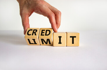 Credit limit symbol. Businessman turns wooden cubes and changes the word 'limit' to 'credit'. Beautiful white table, white background, copy space. Business and credit limit concept.