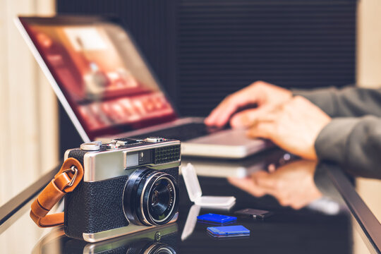 Male Photographer Editing Photo On Laptop Computer, Focus On Camera On Desk