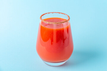 Traditional Mexican cuisine: alcoholic drink Michelada. Cocktail with tomato juice: Bloody mary, sangrita, ceviche mary on blue background.