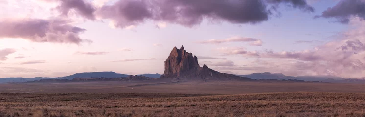 Fototapeten Lila Panoramische amerikanische Naturlandschaftsansicht der trockenen Wüste und der zerklüfteten Rocky Mountains. Bunte Sonnenaufgang-Himmel-Kunst-Render. Aufgenommen bei Shiprock, New Mexico, USA.  © edb3_16