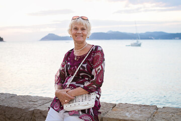 Fototapeta na wymiar Senior Woman Relaxing by the sea on the seashore