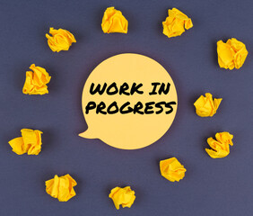 Among the crumpled pieces of paper lies a sticker sheet with the inscription - WORK IN PROGRESS
