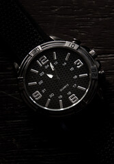 
elegant silver watch with black wood background