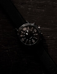 
elegant silver watch with black wood background