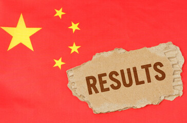 Against the background of the Chinese flag lies cardboard with the inscription - results