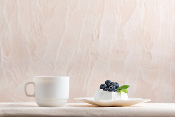 Cup of coffee next and berry dessert. Fresh blueberry meringue cake and tea