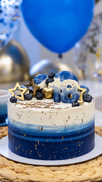 Handmade birthday cake on a blurred background with balloons and sparkles. Cheesecake cake, blue and gold accents. Festive background for postcard, holiday, birthday, anniversary, 18 years. 
