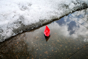 A boat made of paper. Red as a symbol of a leader and business drowning in times of crisis, pandemic.