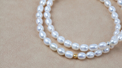 Luxury elegant baroque pearl bracelets on beige textured leather background