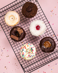 Top view of colourful donuts flat item.Desserts and sweet snacks concept. Pink background.