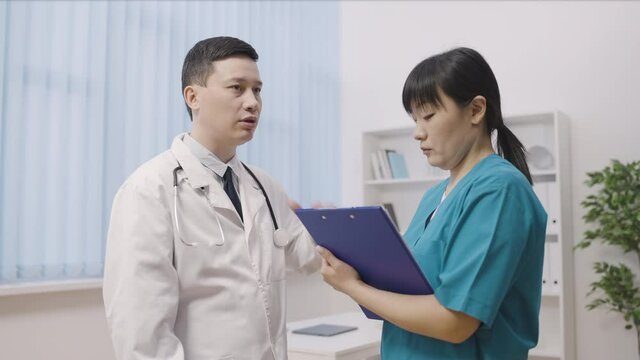 Active Asian Doctor Giving Instructions To Nurse, Professional Team, Hospital