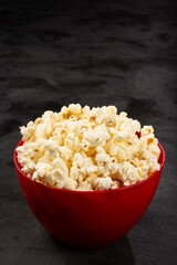 Bowl with salted popcorn sore the table.