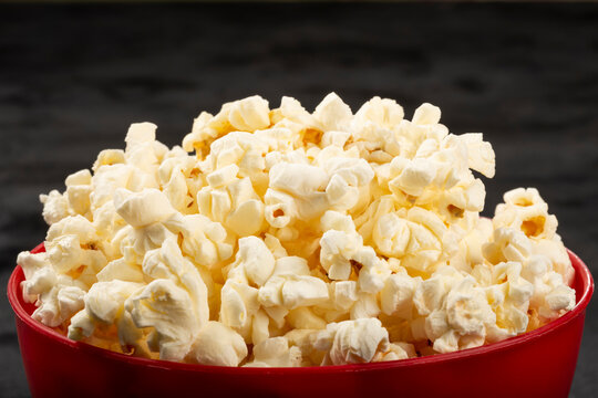 Bowl with salted popcorn sore the table.