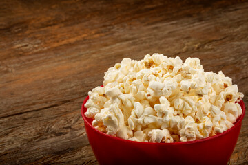 Bowl with salted popcorn sore the table.