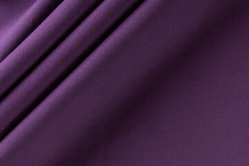 dense curtain cotton fabric of deep purple color, folded in folds, background