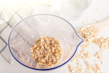 Step by step recipe. Cooking oat vegetable milk. Step 2 pour oatmeal with water in blender. Homemade food concept. Plant based organic veggie milk, lactose free