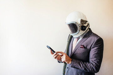 Businessman with astronaut helmet using smart phone