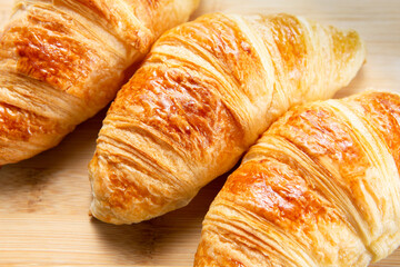 Closeup of three croissants on a wooden table