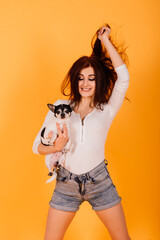 Young woman cuddling chihuahua puppy in studio