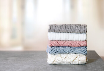 Soft knitted clothes stack,woolen apparel folded on table. Winter garment.Stacked clothing.