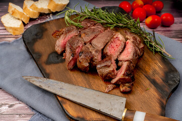 Churrasco of meat cut into pieces on a wooden board in a rustic setting. Aereal view