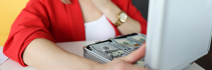 Woman looking in surprise into suitcase with lot of money closeup © megaflopp