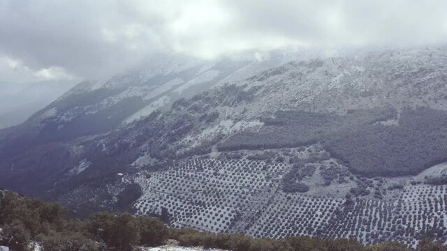 Aerial drone reveal shot showing a mountain after a snow storm in South Spain