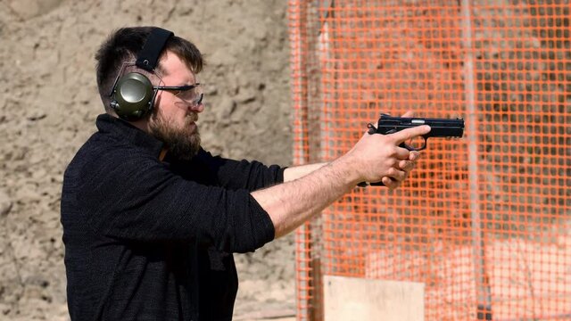 Man fires automatic handgun pistol during training in practical shooting. A man practicing shooter a pistol	