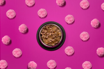Cat food on a pink background. The bowl is full of food. Top View
