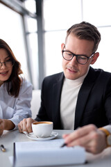 young caucasian entrepreneur sit working in restaurant over a cup of coffee