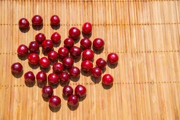 Red cherry berries on a bamboo napkin. The concept of healthy natural food.