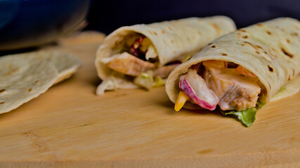 tortillas de trigo enrolladas con pollo, salsa yogur con base vegetal y queso edam. Burritos comida mexicana